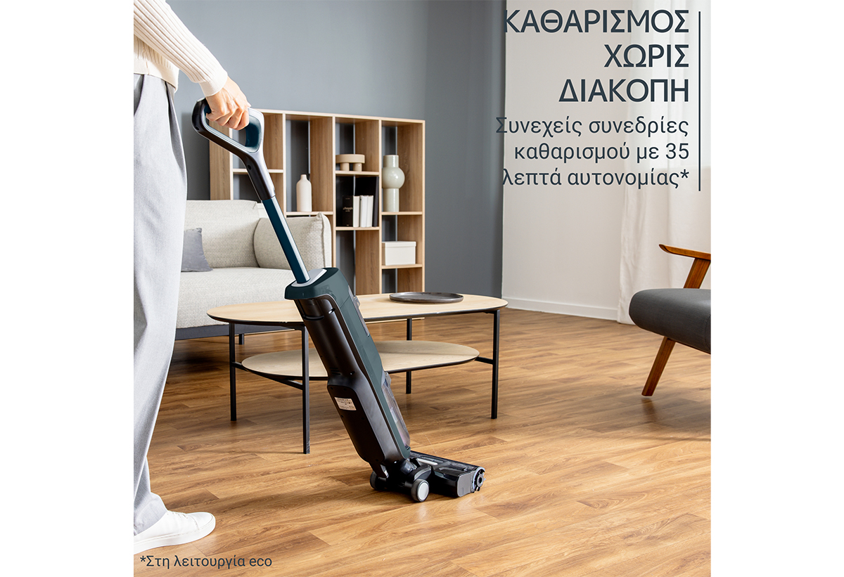 Απεικονίζεται ο καθαρισμός του σαλονιού με τη σκούπα.